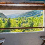 The tranquil view along the valley in the Alpujarras in Granada province Spain viewed from an internal balcony style window.